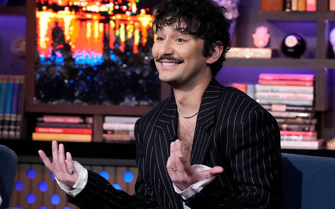 Indelicato as Damien holding cue cards on the late-night set