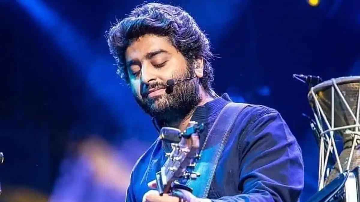 Arijit Singh beaming on stage during a 2024 tour stop